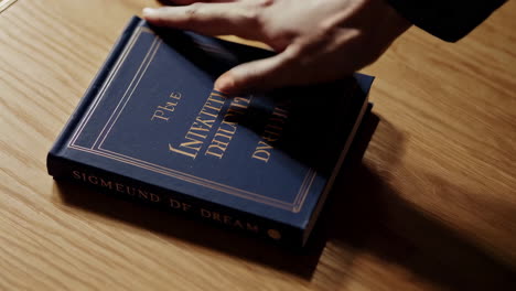 hand pointing to a book about dream interpretation