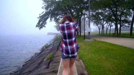 girl back view. walking woman near sea in the park. style woman going back view