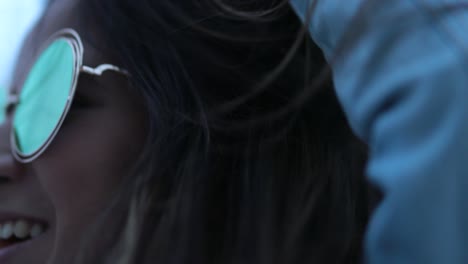 girl wearing fun big round sunglasses, wind blowing hair