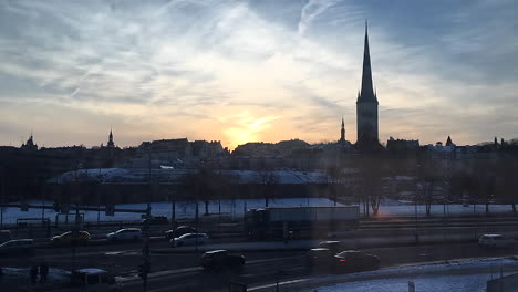 time lapse of tallinn city in estonia going from day to night with traffic and sunset