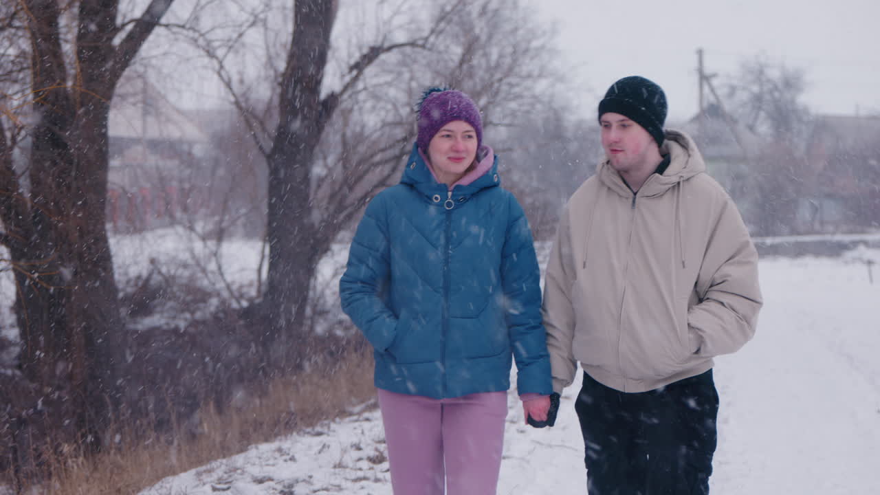 Una pareja caminando en la nieve.