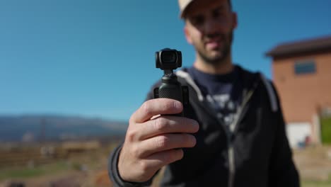 hombre mostrando moderna dji osmo bolsillo 3 estabilizado inteligente seguimiento cámara móvil