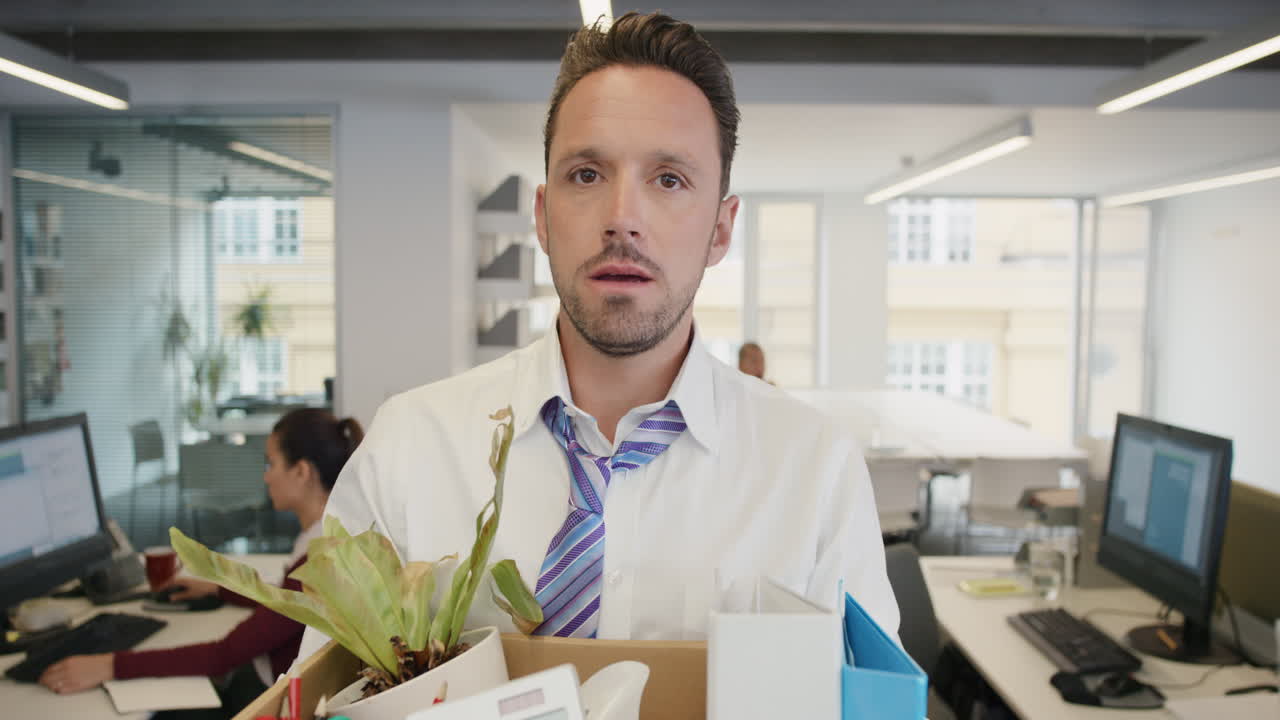 Businessman getting fired carrying box of personal belongings being made redundant in recession sad worried failure