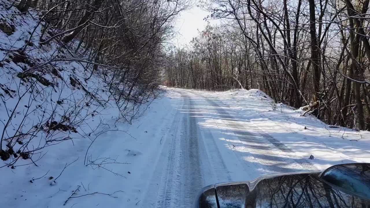 coche 4x4 conduciendo por una carretera de montaña nevada en un soleado día de invierno, tiro rodante