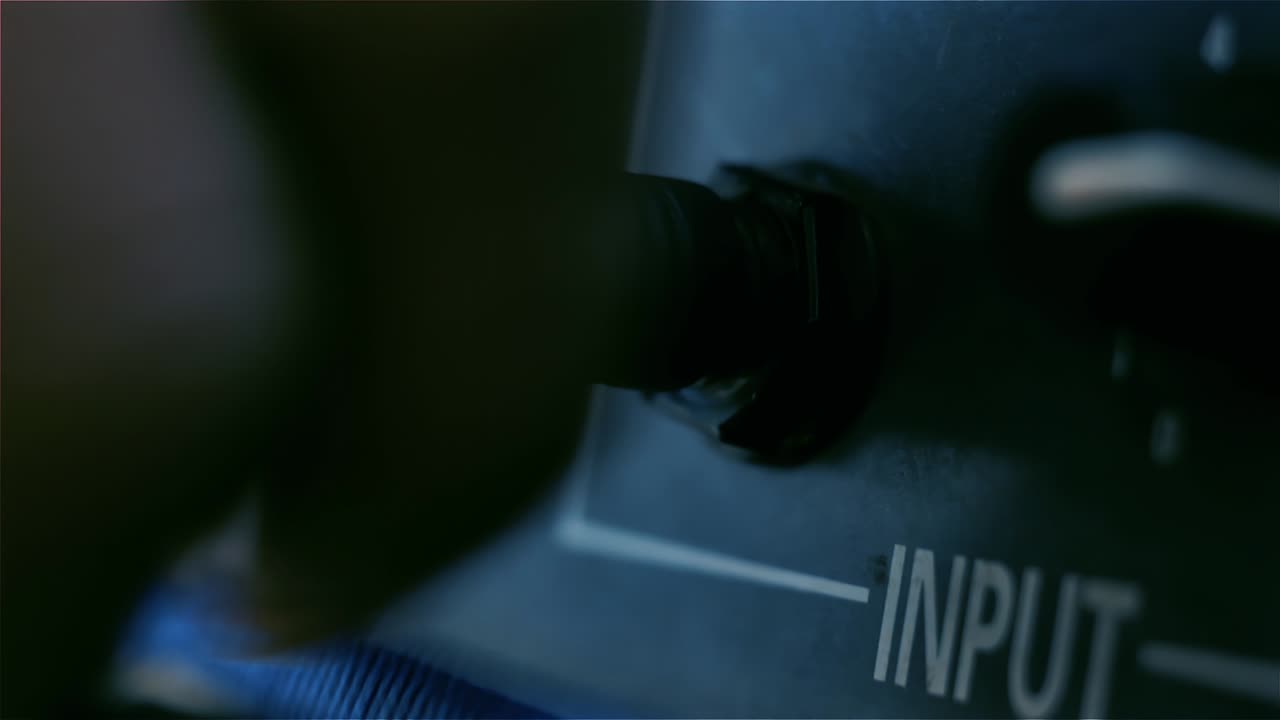 hombre conectando a mano el enchufe de audio de jack en el amplificador de guitarra al aire libre. cerca. resolución 4k.