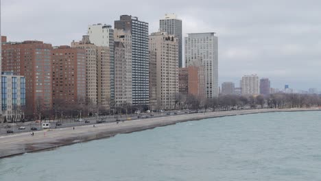 Drone-shot-of-beachfront-apartment-buildings-and-Lake-Shore-Drive-expressway-alongside-shoreline-of-Lake-Michigan,-Chicago,-Illinois,-United-States