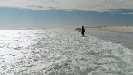 Woman-with-surfboard-walking-on-the-sea-4k