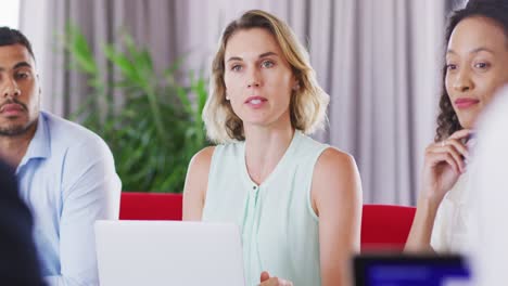 mujer de negocios profesional hablando con sus colegas mientras está sentada en una oficina moderna en cámara lenta