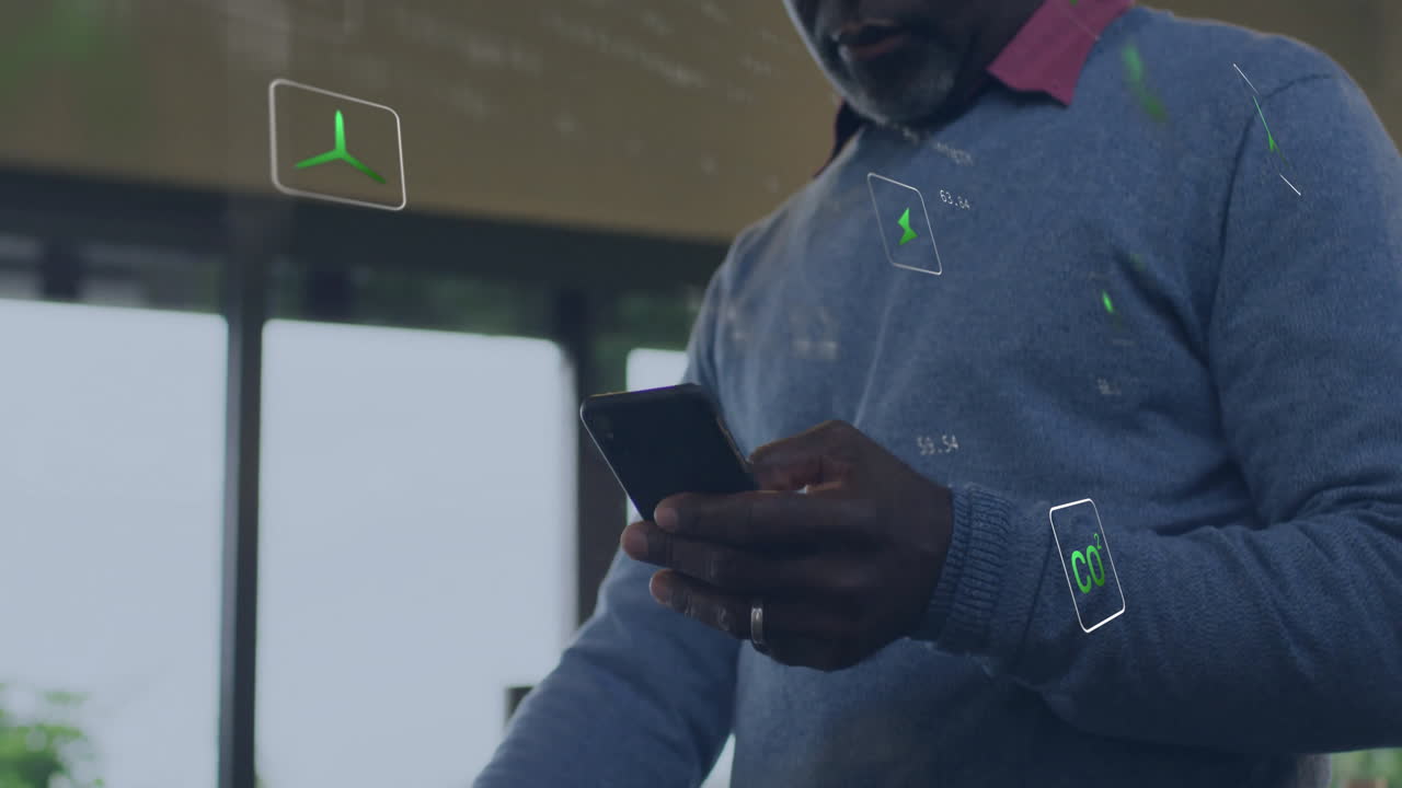 Animation of energy and ecology icons over senior african american man using smartphone at home