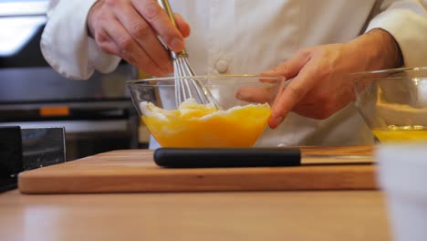 the cook mixes the egg with sugar in a bowl