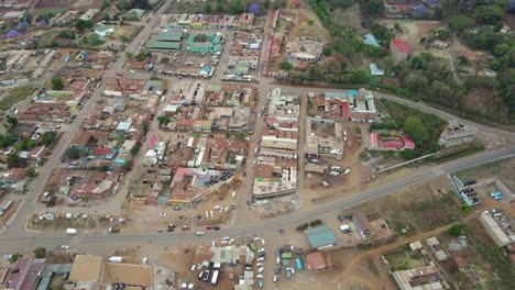 aerial view of a town and sunlit fields, golden hour in rural africa - tracking, drone shot