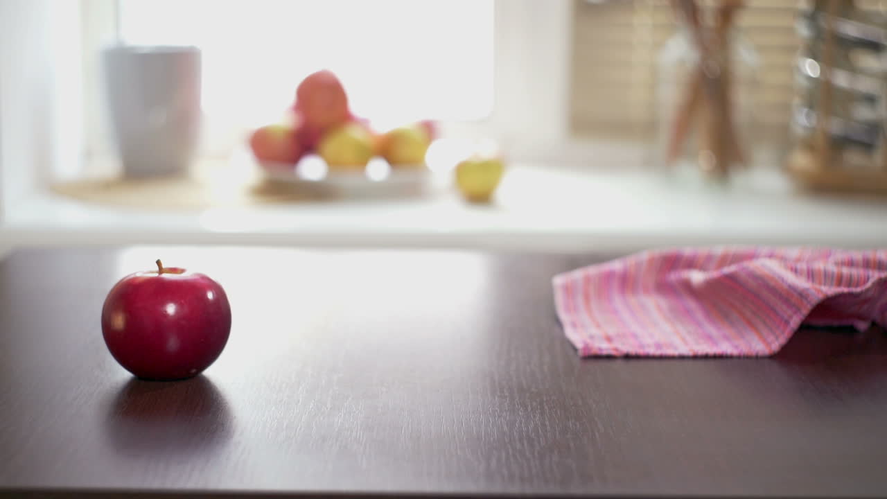 Red apples on wooden table. Hand putting a ripe red apples on a wooden table