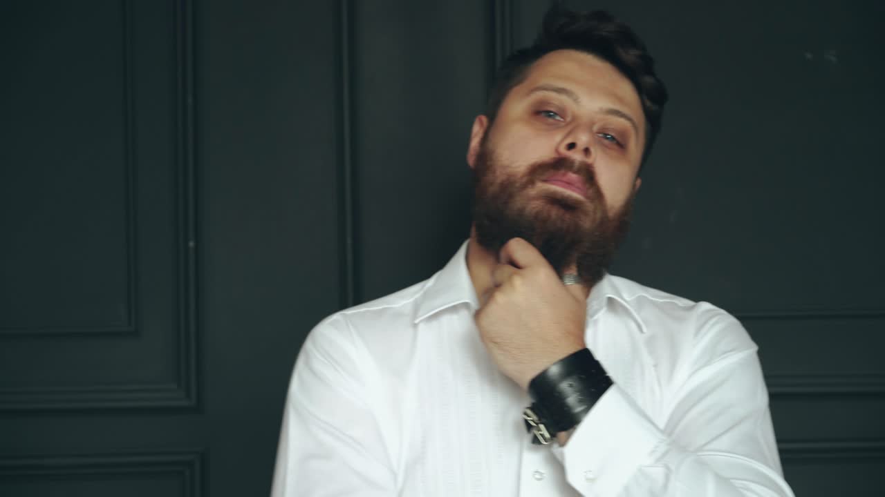 Bearded man in studio. Young handsome bearded man on serious face in studio