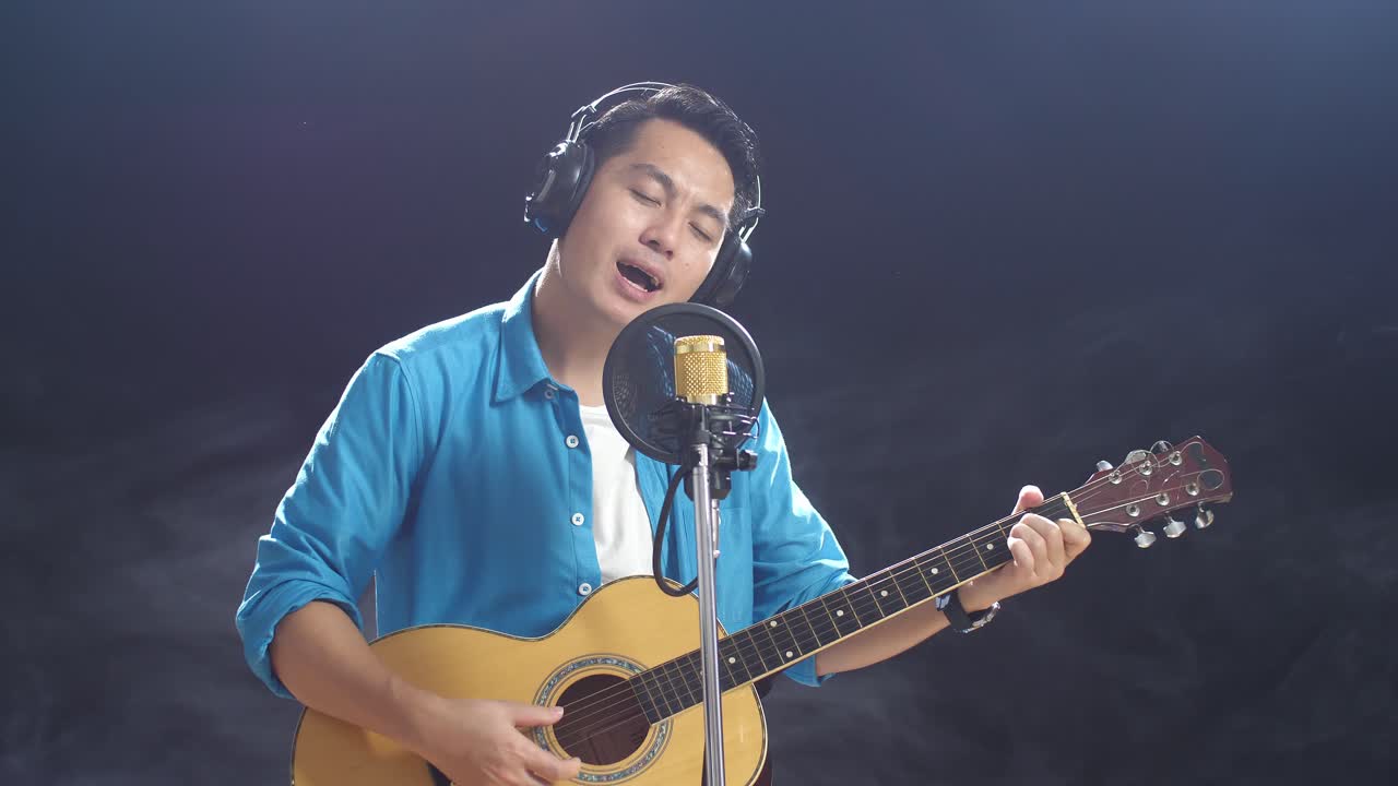 노래 하고 어쿠스틱 기타를 연주 하는 남자