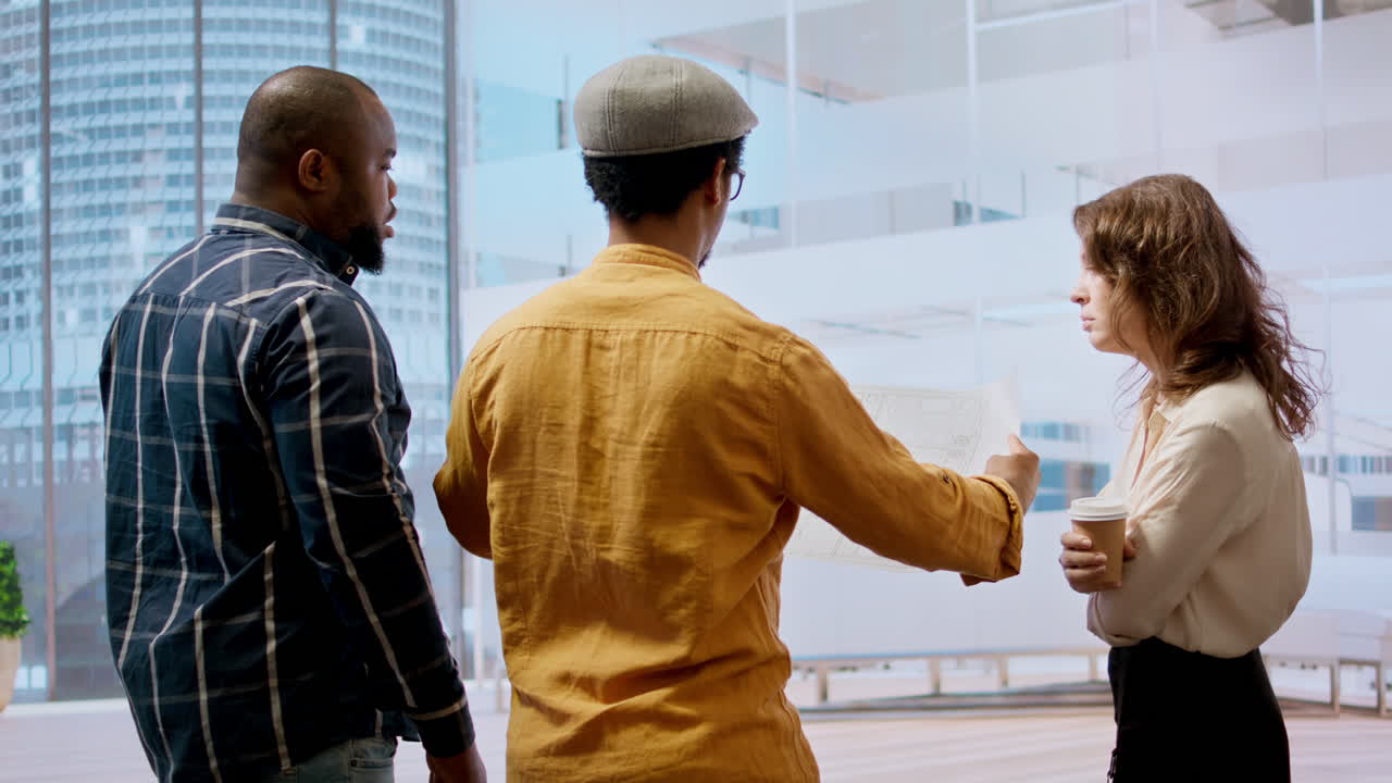 equipo profesional recorriendo un espacio de oficina con un agente inmobiliario