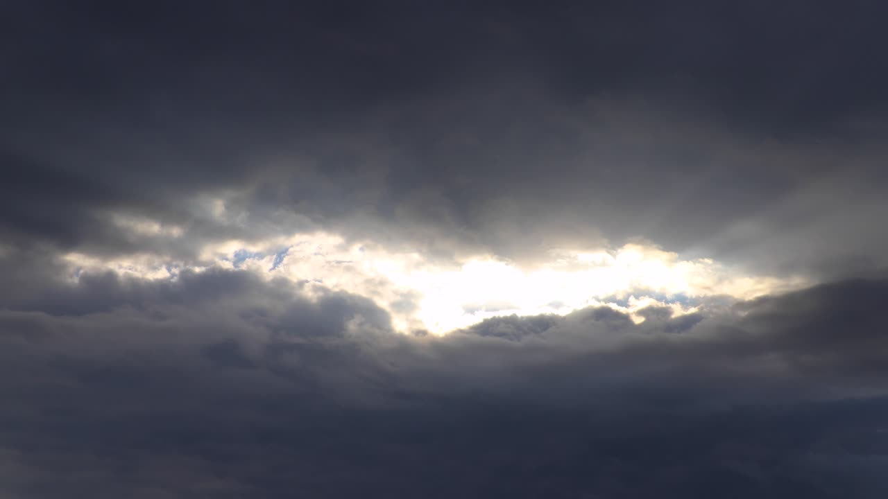 Time lapse of dark clouds with sun light pushing through them