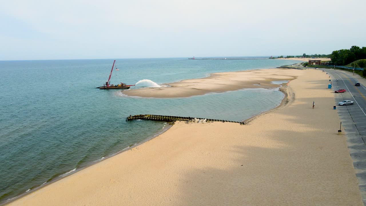 새로운 해안선을 채우기 위해 pere marquette 해변을 준설 중입니다.