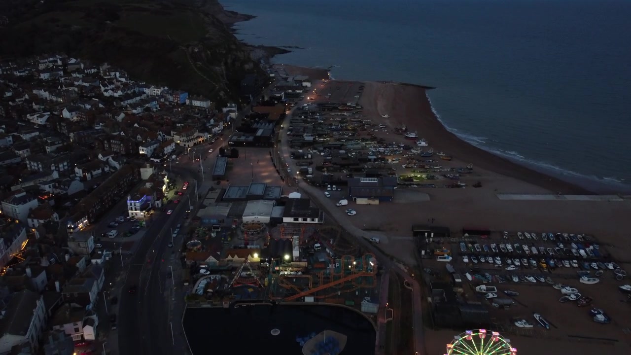 Il drone effettua una panoramica sulla spiaggia di Eastbourne, catturando pescherecci e la costa sotto cieli crepuscolari.