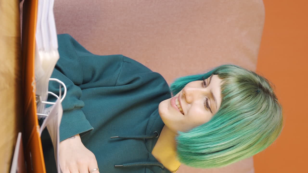 파일을 검토하는 젊은 여성의 수직 비디오는 그녀의 머리로 파일을 승인합니다.