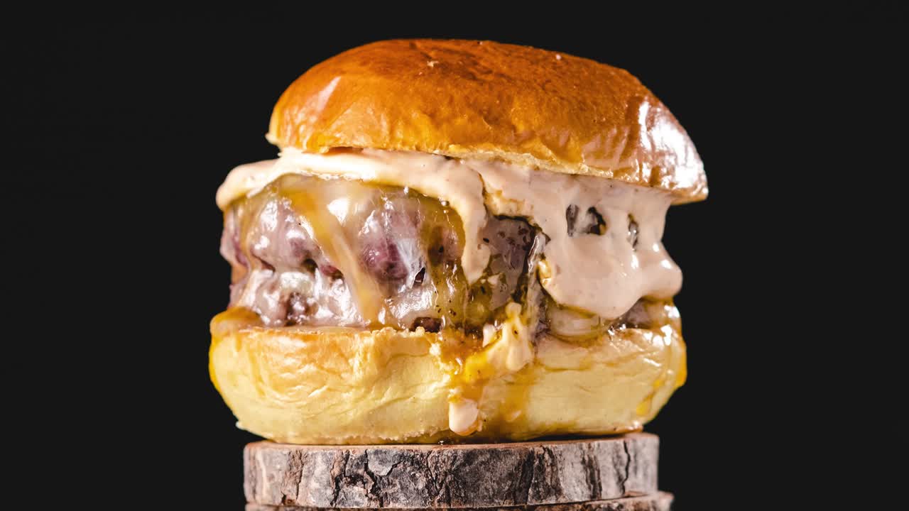 Delicious burger rotating on wooden stand. stop motion