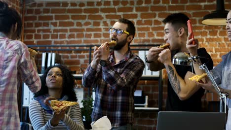 colegas en la oficina comiendo pizza juntos