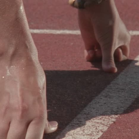 a runner kneels at the starting line then starts racing