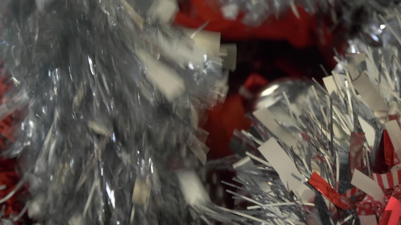 picking up silver chritmas tinsel from a xmas decorations box
