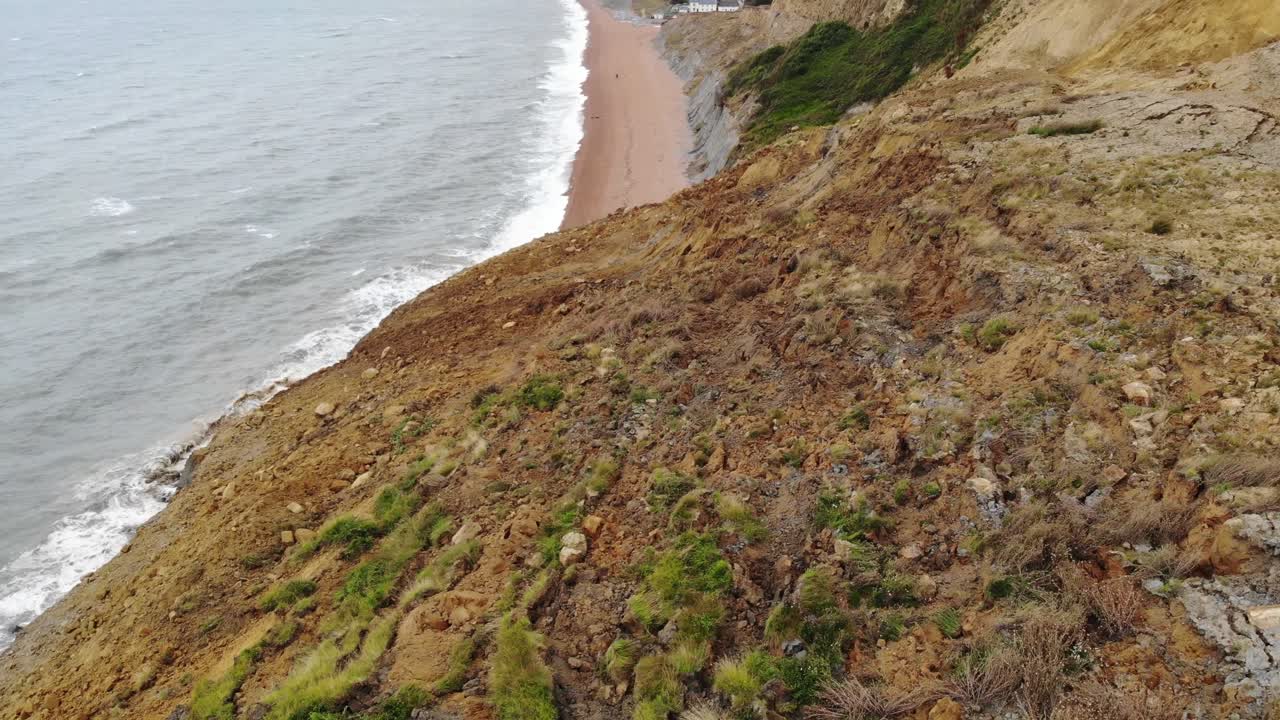 volando sobre un gran deslizamiento de tierra costera con inclinación hacia arriba para revelar la playa de seatown en dorset