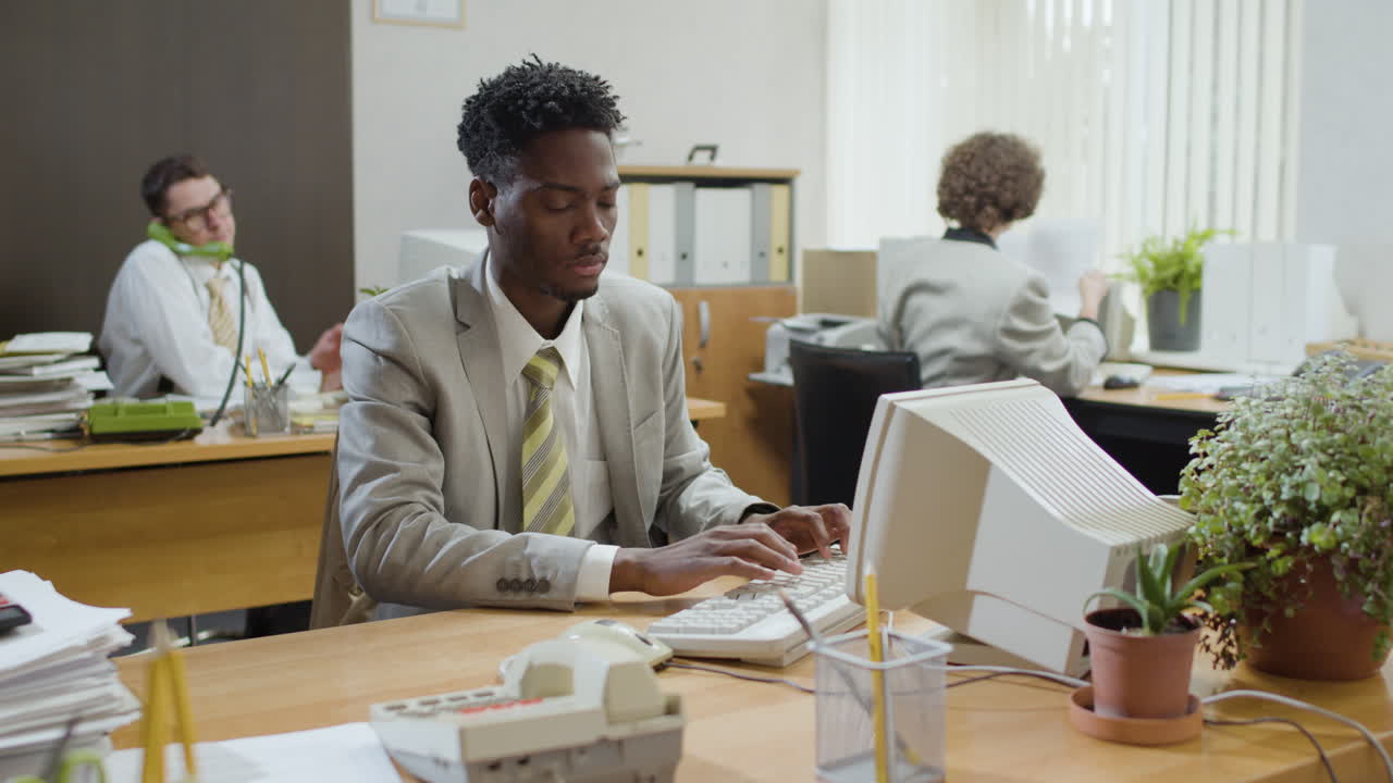 African american businessman working sitting at desk and talking on the phone in a vintage office.