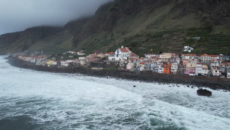 fantastica toma aerea sobre la costa de la ciudad de paul do mar, en la isla de madeira, donde se pueden ver las olas rompiendo contra la costa