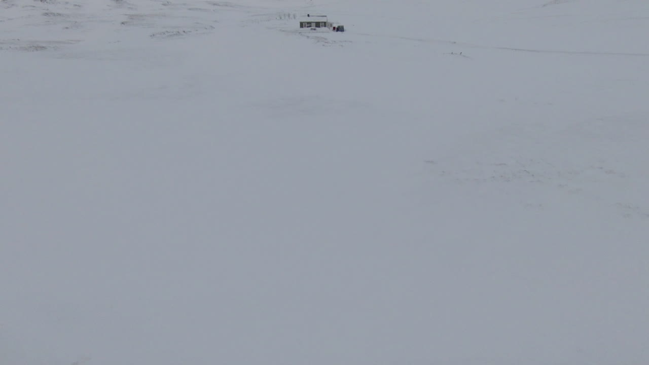 вид на занесенную снегом хижину в глуши