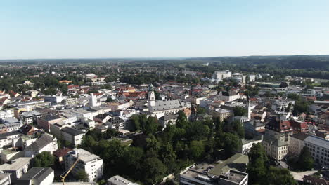 Aerial shot of the city of Rosenheim showing the NeogothicSt. Nikolaus Church flying backwards revealing thebeautiful old town and the landscape behind the city.