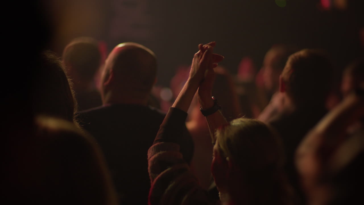 Audience Clapping and Raising Hands at a Live Concert