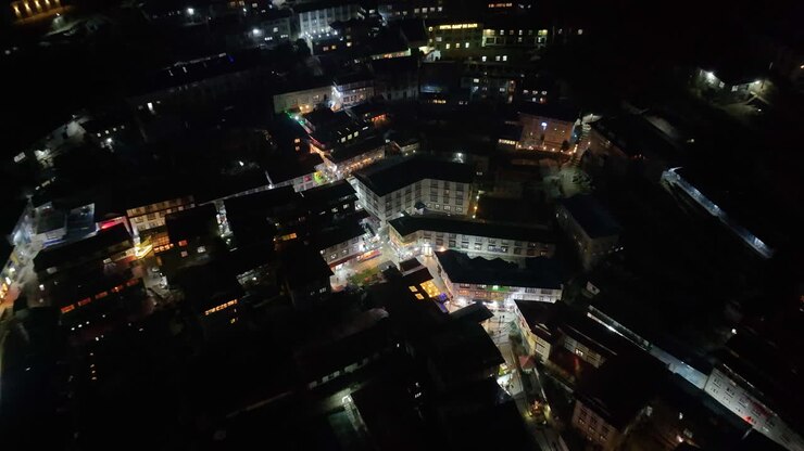 Drone shot of Namche Bazaar village at night in the Himalayas, showcasing solar-powered electricity illuminating homes and lifestyle of Nepalese at high altitude