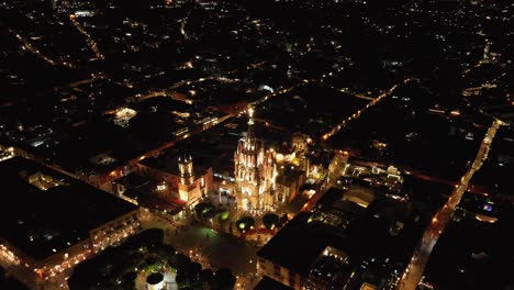 Nighttime-orbit-looking-over-Parroquia-de-San-Miguel-Arcangel,-Jardin-Allende,-El-Campanario-and-Quiosco-Picorete-in-San-Miguel-de-Allende