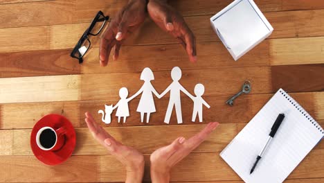 close-up of cutout paper chain family with the protection of hands