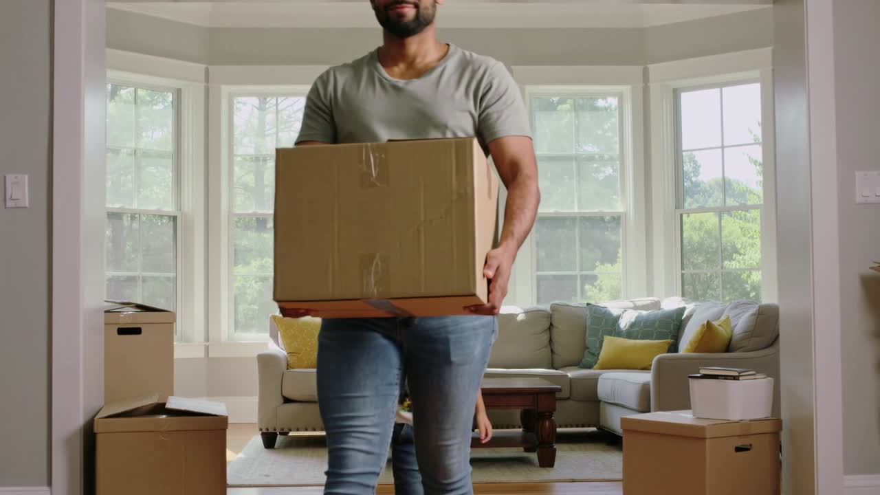 Homem segurando uma caixa grande entrando pela porta, com uma criança atrás, e indicações de movimento guiando-o a colocar as caixas para a mudança