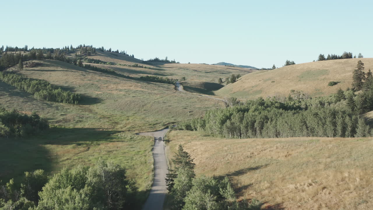 antena de carretera a través de colinas cubiertas de hierba en el pintoresco paisaje canadiense remoto