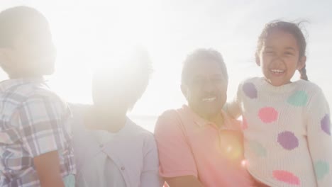 Glückliche-Hispanische-Großeltern-Und-Enkelkinder,-Die-Sich-Bei-Sonnenuntergang-Am-Strand-Vergnügen