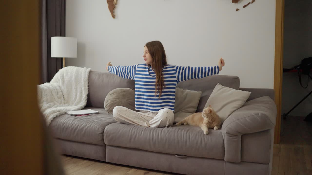 Girl with cat sitting on couch at home
