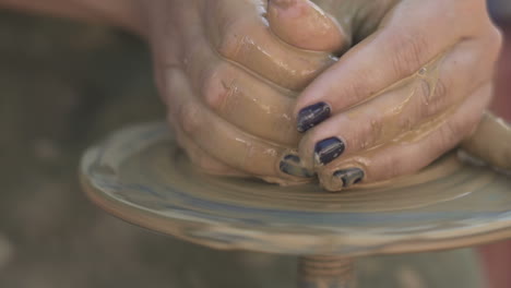 woman making pottery on wheel