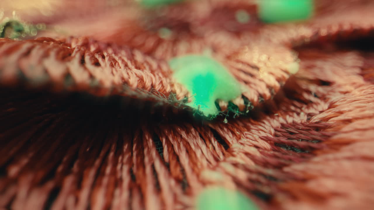 Close-up view of embroidered fabric with green beads