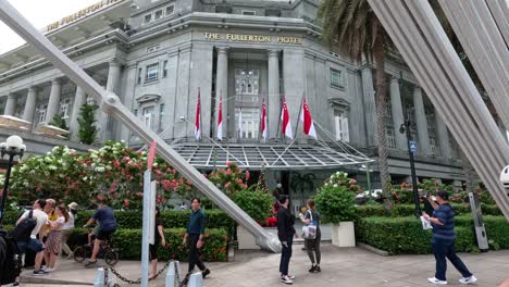 people walking and posing in front of a grand building.