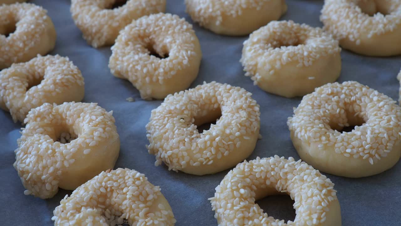 Close-up sesame seeds stuck to the dough, tiny bagels with sesame seeds,