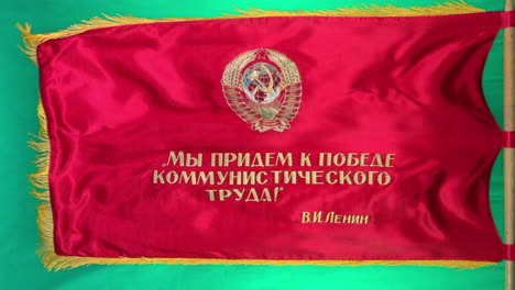 soviet parade flag with propaganda slogans flies from flag pole with green screen background