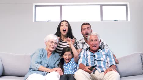 cute family watching tv on the couch