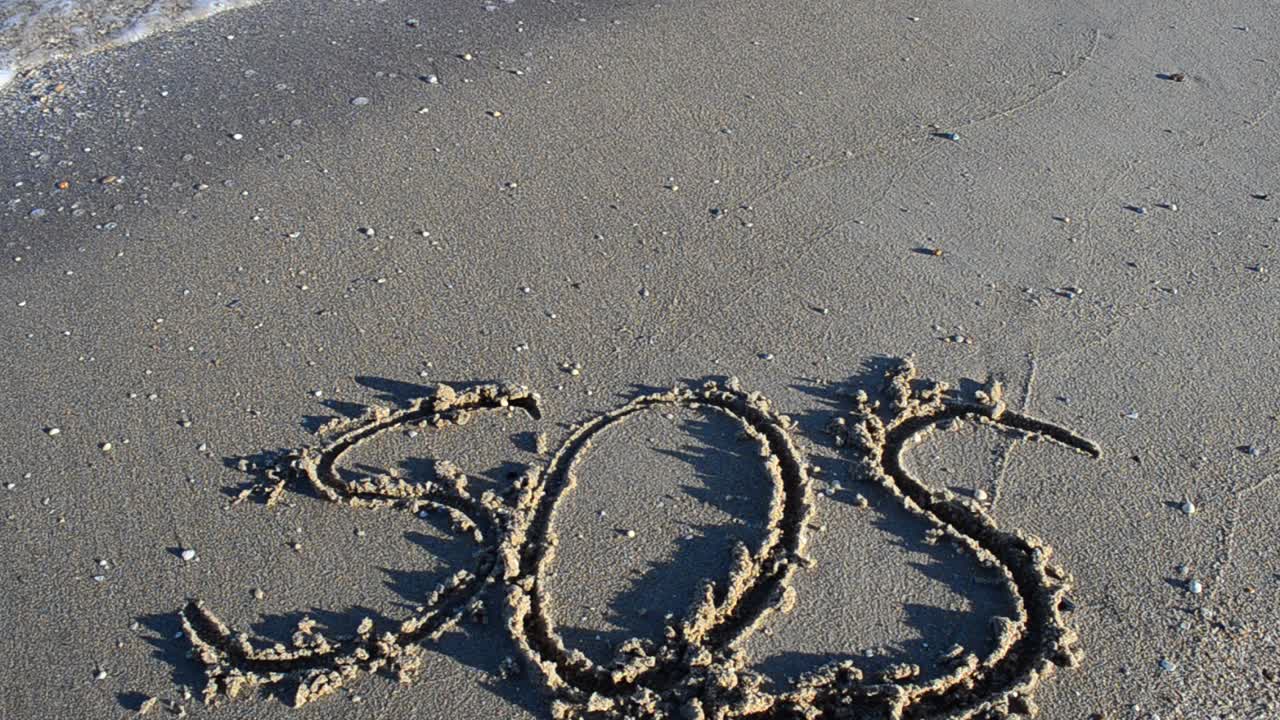 The inscription SOS on sand. Shooting on the beach