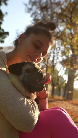 girl hugging a pug in a park