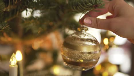 Closeup:-Hanging-golden-transparent-christmas-bauble-on-decorated-tree