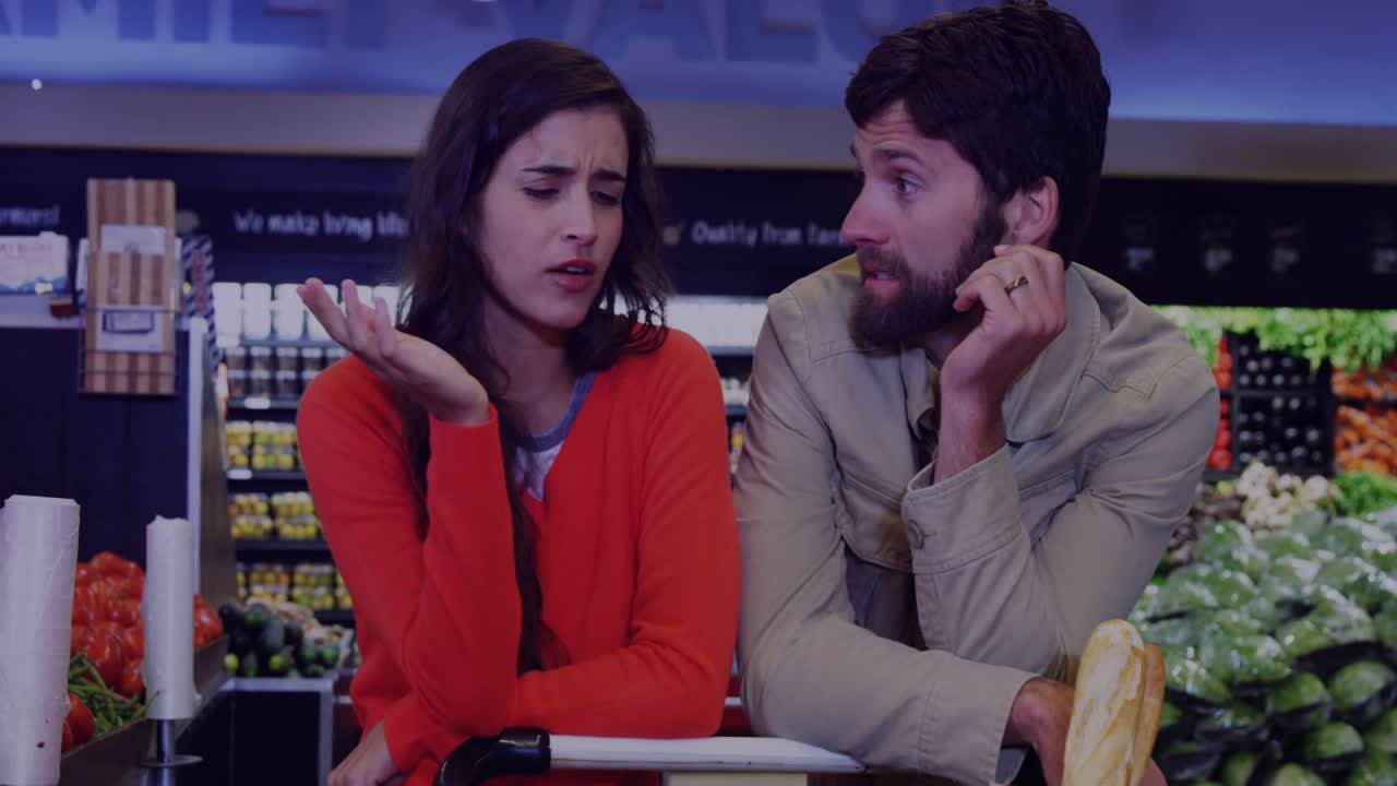 Couple at grocery counter, woman raising hand frustrated then pausing, glare bands over them